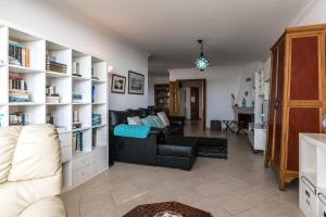 a living room with a couch and book shelves at Casa das Conchas in Ericeira