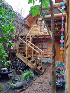 una cabaña de madera con una escalera delante de ella en Posada la Piedra, en Constitución