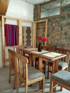 een houten tafel en stoelen met bloemen erop bij Posada la Piedra in Constitución