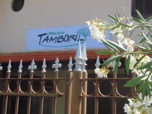 a fence with white flowers and a sign in the background at Pousada Tamboril in Brumadinho