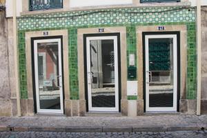 リスボンにあるドバイロ スイーツ アット バイロ アルトの緑瓦造りの建物の横に三面鏡