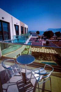 patio con mesa y sillas en el balcón en Crystal Bay Hotel, en Kissamos