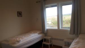 Rúm í herbergi á Hjartarstaðir Guesthouse