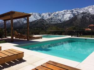 a swimming pool with a view of snow covered mountains at Parque Los Nogales Apart Hotel in Merlo