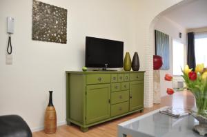 een woonkamer met een groene dressoir en een televisie. bij "2600" in Antwerpen