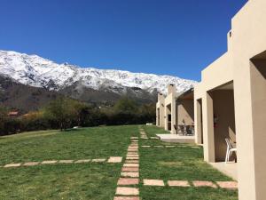 einen Weg zu einem Haus mit einem Berg im Hintergrund in der Unterkunft Parque Los Nogales Apart Hotel in Merlo
