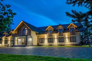 a large house with a dark roof at Hotel *** Rancho Lot in Nowy Targ +29 photos