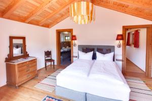 Schlafzimmer mit einem Bett, einer Kommode und einem Spiegel in der Unterkunft Apartements Luna Blanca in Schwangau