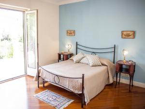 een slaapkamer met een bed met 2 nachtkastjes en een raam bij Villa Glicini in Lamezia Terme