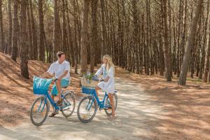 Un homme et une femme qui roulent à vélo sur un chemin de terre dans l'établissement Oleandri Resort Paestum, à Paestum