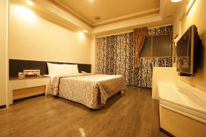 a bedroom with a bed and a sink and a tub at Hua Yue Hotel in Taoyuan