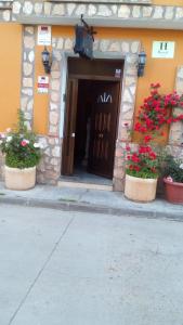 un edificio con vasi di fiori davanti ad una porta di Hostal Cañamares a Cañamares