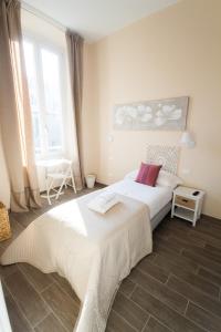 a bedroom with a large white bed and a window at Emily Rooms in Sanremo