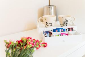 a shelf with cups and a vase with flowers at Emily Rooms in Sanremo