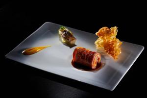 a white plate with food on a black background at Occidental Faro in Faro