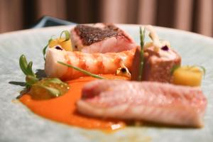 a plate of food with salmon and meat on it at Occidental Faro in Faro