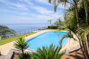 a swimming pool with a view of the ocean at Peace Haven in Calheta