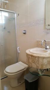 a bathroom with a sink and a toilet and a shower at Hipolitus Apart Hotel in Lagarto