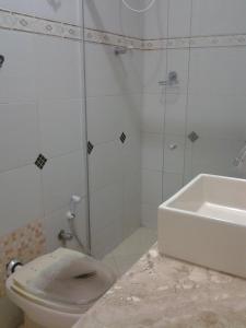uma casa de banho com um WC, um chuveiro e um lavatório. em Hipolitus Apart Hotel em Lagarto