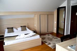 1 dormitorio con 1 cama con cabecero de madera en Casa Caroli en Târgu Jiu