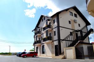 a building with a red car parked in front of it at Casa Caroli in Târgu Jiu