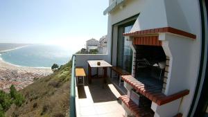 einen Balkon mit einem Tisch und Meerblick in der Unterkunft Casa da Buzina in Nazaré
