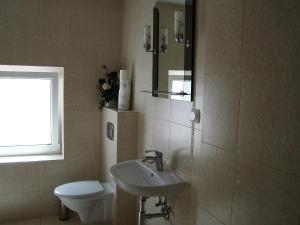 La salle de bains est pourvue d'un lavabo et de toilettes. dans l'établissement Pokoje Przy Kominie, à Piecki