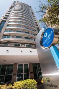 un edificio con una señal azul delante de él en Transamerica Executive Perdizes en São Paulo