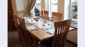 uma mesa de madeira com cadeiras e uma sala de jantar em Elgin Self Catering Holiday Cottage em Elgin