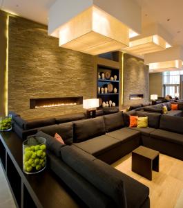 a living room filled with furniture and a fire place at Van der Valk Airporthotel Düsseldorf in Düsseldorf