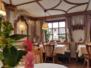 a restaurant with tables and chairs and a window at Hotel Rosenbusch in Großheubach