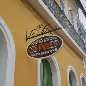 a sign hanging on the side of a building at Hostel Casa de Avany in Cachoeira