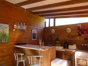 a kitchen with a counter and stools in a cabin at Gîte 1001 Nuits - SINBAD in Bouillante