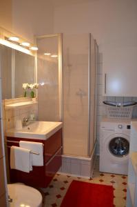 a bathroom with a shower sink and a washing machine at Ferienwohnung Barfly in Traben-Trarbach