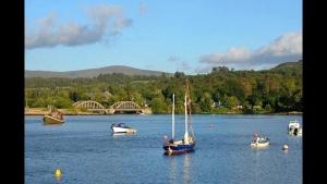 a sail boat floating on a lake with other boats at The White House B & B in Kenmare