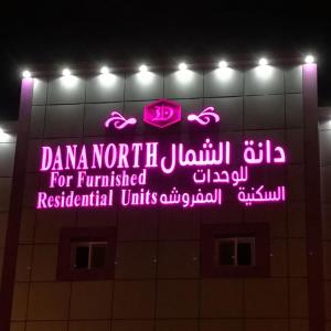 a neon sign on the side of a building at Dana North in Al Qurayyat
