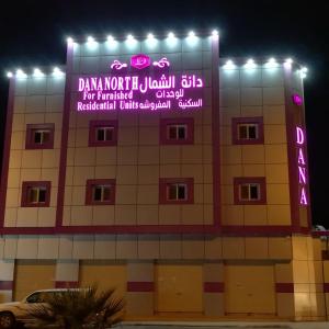 ein Gebäude mit Neonschildern an der Seite in der Unterkunft Dana North in Qurayyat