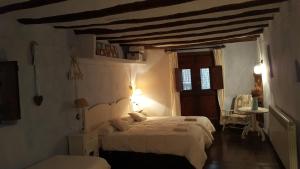 a bedroom with a white bed and a wooden ceiling at Carmen De Arnas in Colungo