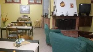 sala de estar con chimenea, mesas y sillas en B&B La villetta rossa, en Anzio