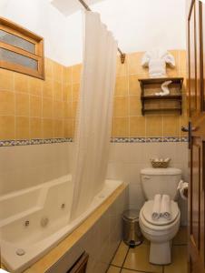 a bathroom with a toilet and a tub and a shower at Hostal San Nicolas in Antigua Guatemala