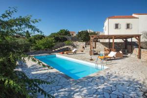 una piscina en un patio con una casa en Villa Cerigo en Aroniadika