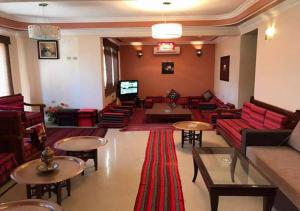 فندق دهب في دهب: غرفة معيشة مع كنب وطاولات حمراء