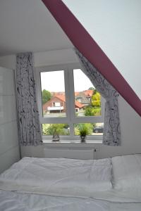 a bedroom with a bed and a window at Steuerbord in Horumersiel