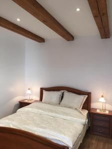 a bedroom with a bed with two lamps on tables at Skapas Street Vilnius in Vilnius
