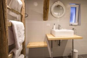 un baño con lavabo y espejo en La Grange aux Coqs, en Ittenheim
