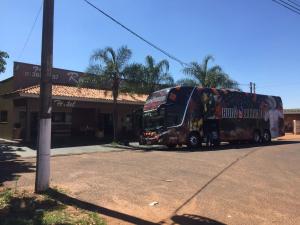 um autocarro de dois andares estacionado em frente a uma loja em Recanto Village Hotel em Cosmorama