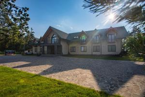 a house with a stone driveway in front of it at Hotel *** Rancho Lot in Nowy Targ