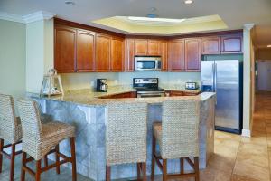 a kitchen with a large island with bar stools at Phoenix West II Unit 1109 in Orange Beach