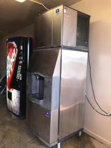 a large metal refrigerator in a room with a skateboard at Red Carpet Inn in Hot Springs