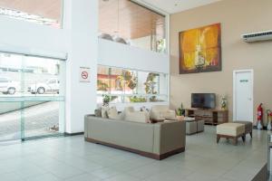 vestíbulo con sofá y TV en un edificio en Apartamentos Deluxe Ponta Negra Beach, en Natal
